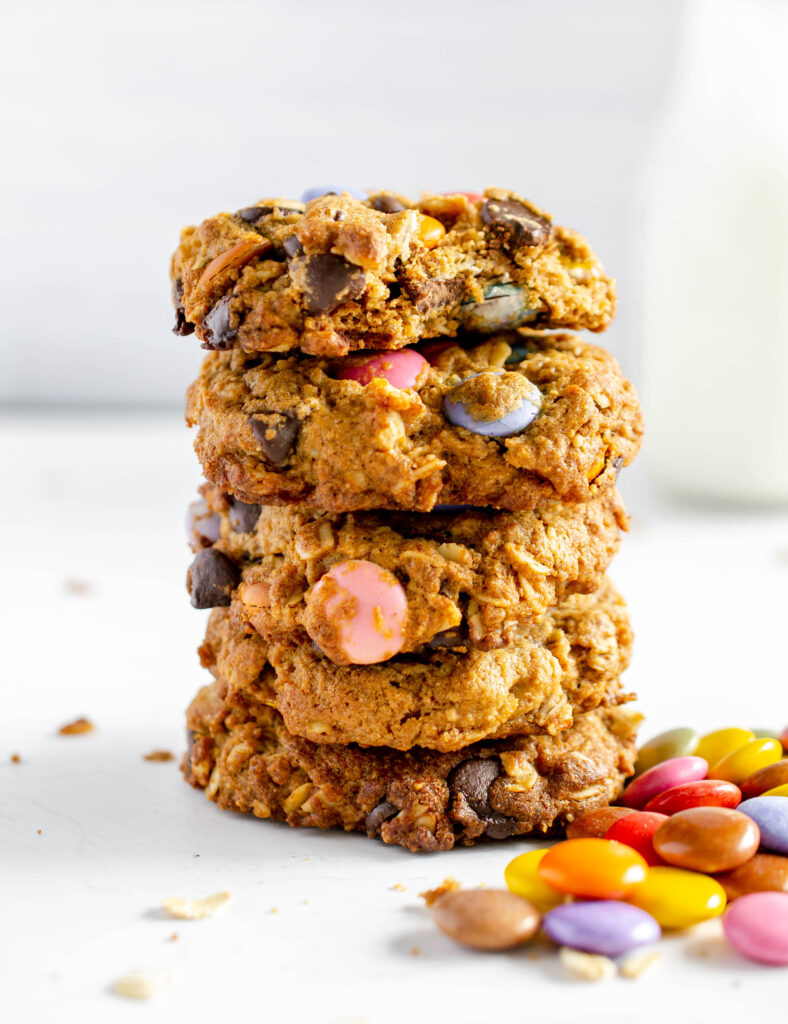 stack of monster cookies next to chocolate candies