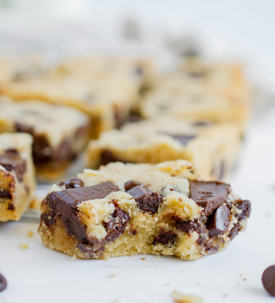 close up photo of a chocolate chip blondie with a bite taken out of it