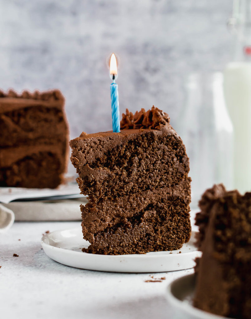 slice of chocolate cake with a birthday candle in it