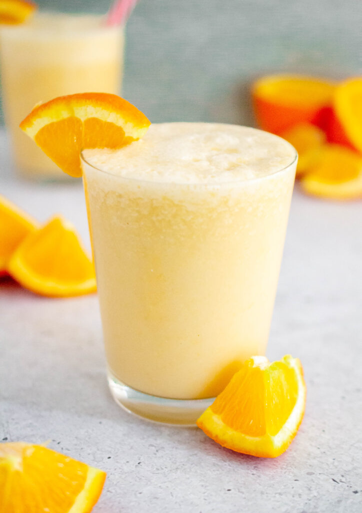 orange julius in a glass with orange slices