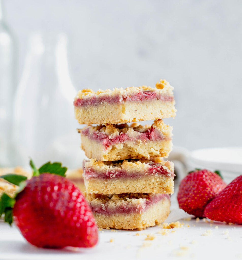 stack of stawberry cookie bars surrounded by strawberries