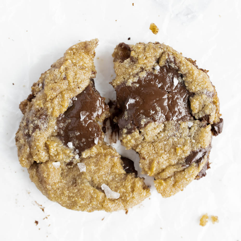overhead photo of gluten free brown butter cookie with melting chocolate and flaky sea salt