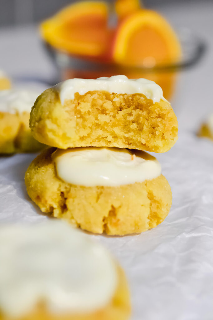 stack of two orange cookies topped with icing.