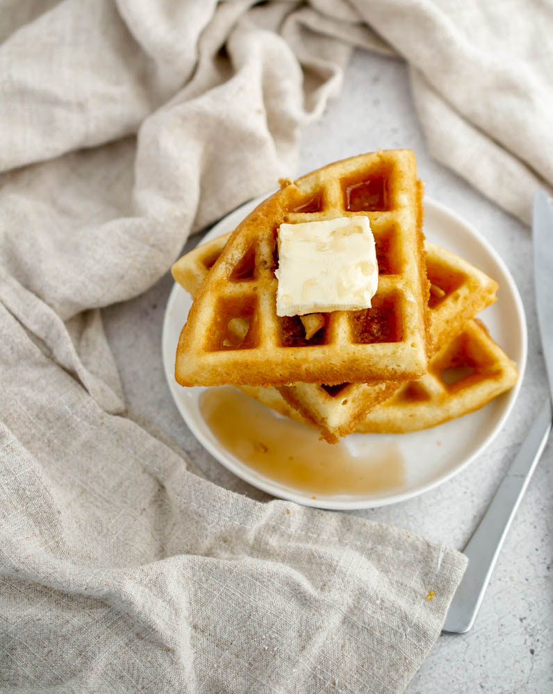 overhead photo of Gluten Free Dairy Free Belgian Waffles topped with butter and maple syrup