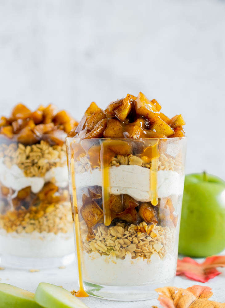 two sugar free caramel apple trifles in clear glasses with apples in the background