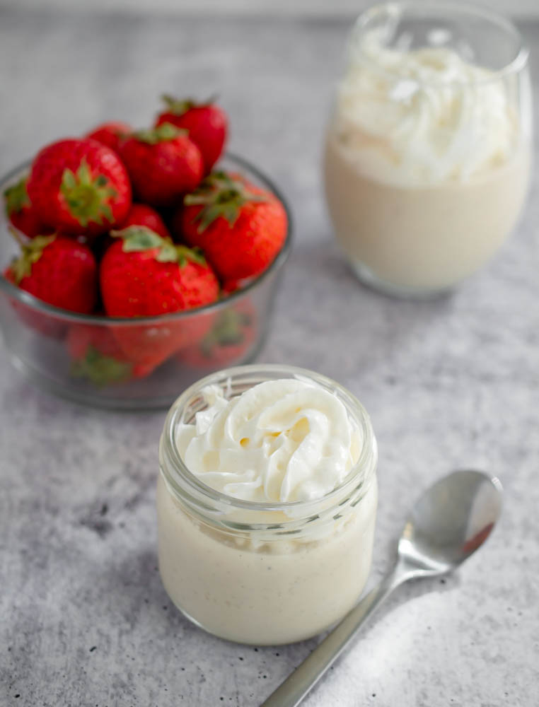 Vegan Keto Vanilla Pudding in a small glass jar topped with whipped cream