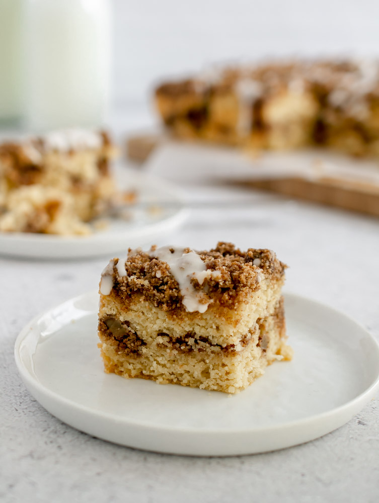 slice of Gluten Free Coffee Cake with a white drizzle on a white plate