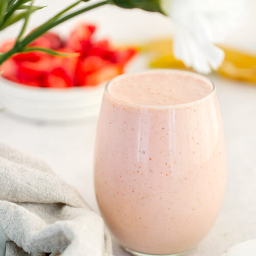 Greek Yogurt Smoothie with strawberries and white flowers in the background