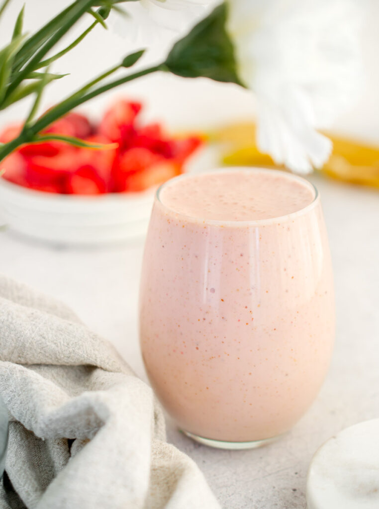 Greek Yogurt Smoothie with strawberries and white flowers in the background