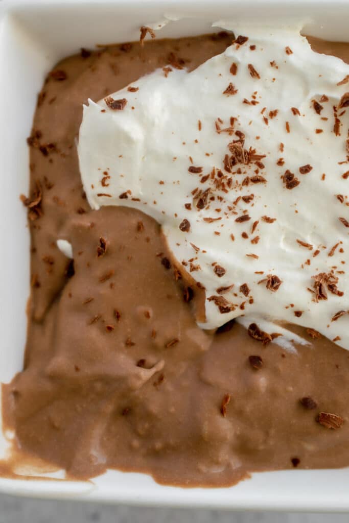 close up photo of Sugar Free Keto Chocolate Pudding topped with whipped cream and chocolate shavings