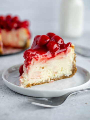 Slice of cherry cheesecake on a white place