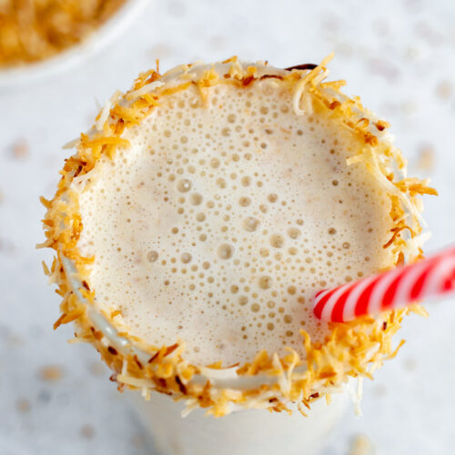 coconut shake in a glass with toasted coconut around the rim