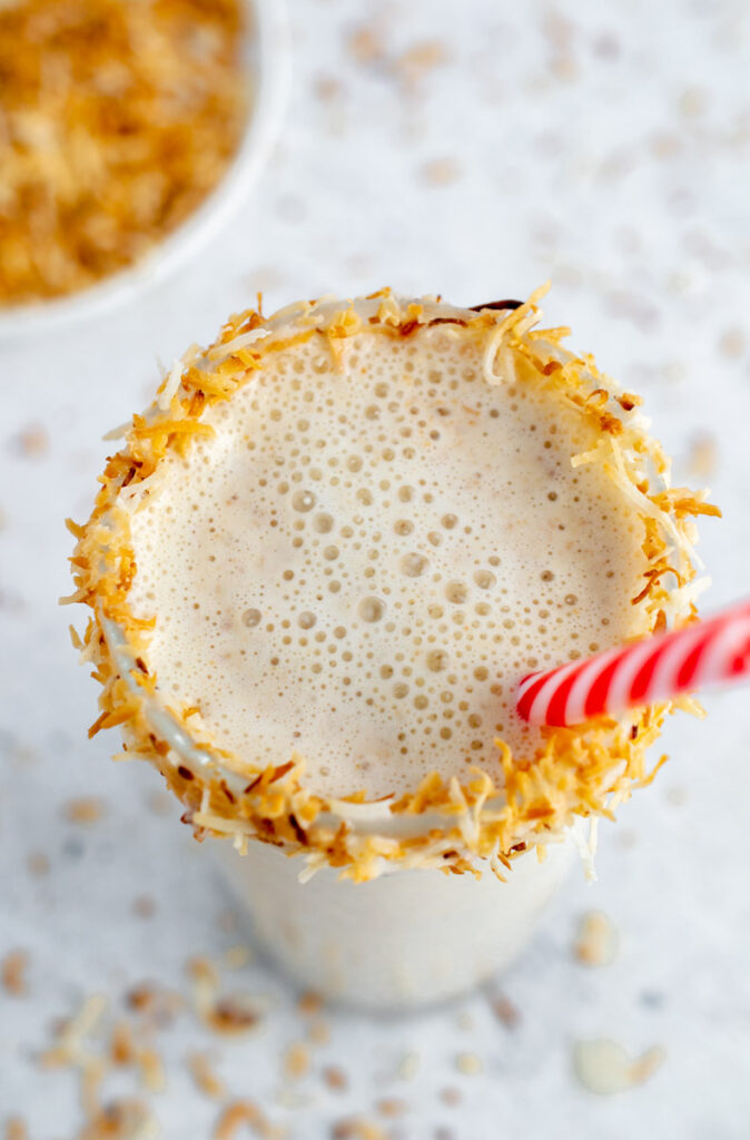 coconut shake in a glass with toasted coconut around the rim