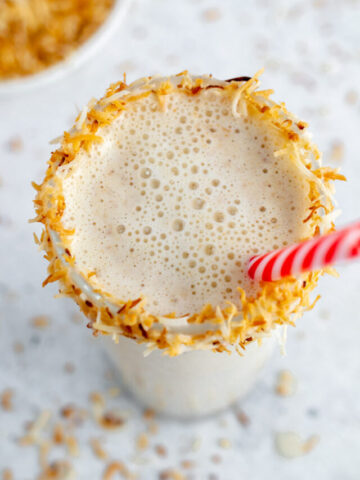 coconut shake in a glass with toasted coconut around the rim