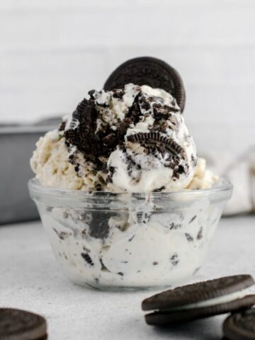 oreo ice cream in a glass bowl topped with a oreo