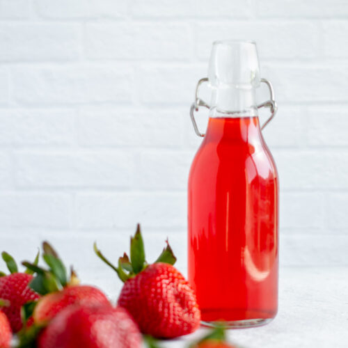 strawberry simple syrup in a glass vessel