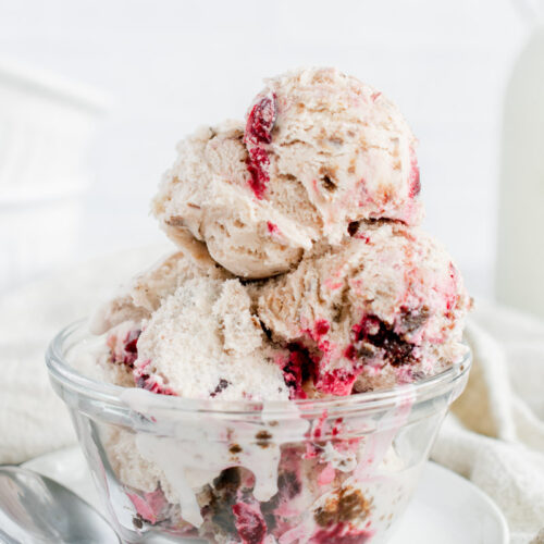 scoops of black forest ice cream in a glass bowl
