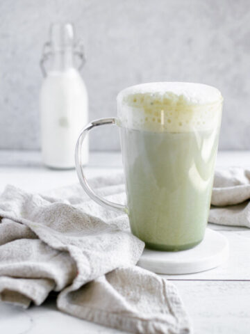 vanilla matcha latte in a glass mug