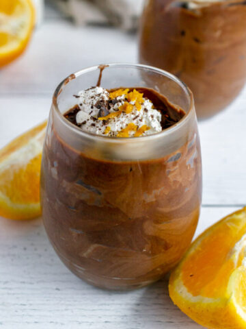 chocolate orange mousse topped with whipped cream, chocolate shavings, and orange zest
