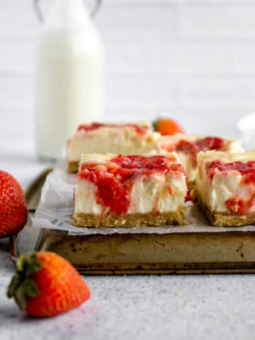 strawberry cheesecake bars on a baking sheet