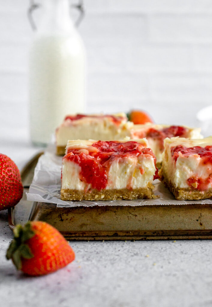 strawberry cheesecake bars on a baking sheet
