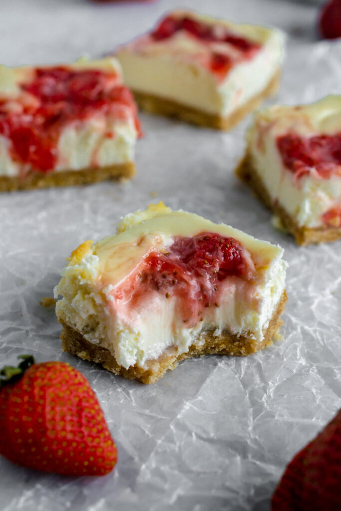 strawberry cheesecake bars with a bite taken out